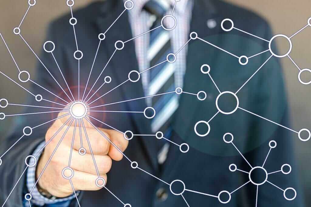 Pont entre le monde réel et virtuel Un doigt se connecte à un réseau polygonal, illustrant la convergence des réalités physique et digitale