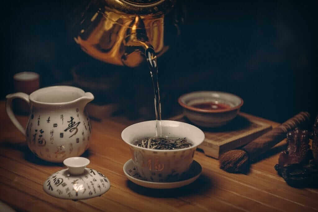 Théière et tasse Théière verse son contenu dans une tasse élégante;